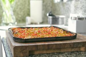 Assorted pizza with tomatoes and peppers placed on tray photo