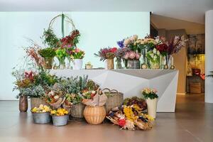 Various blooming flowers placed on counter and floor in floral s photo