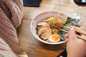 Faceless person enjoying delicious ramen photo