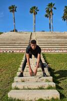 Hispanic man stretching on staircase photo