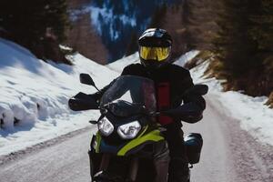 Riding a motorcycle on a snowy mountain road photo