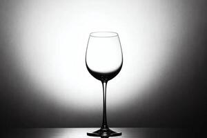 Elegant empty glass stands alone against minimalistic light background in a black and white aesthetic photo