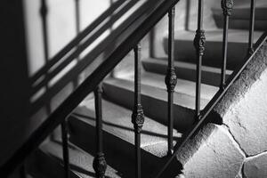Elegant staircase with wrought iron railing illuminated by soft light in a historic building photo