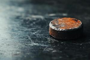 Weathered hockey puck resting on a textured surface. photo