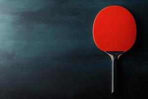 Bright red paddle resting on a dark background. photo