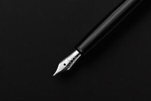 Elegant fountain pen resting on a dark surface. photo