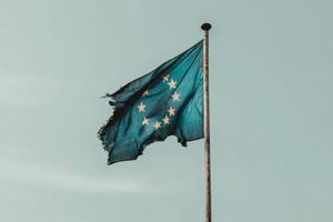 Worn flag of unity fluttering in the breeze. photo