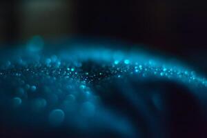 Glowing droplets shimmer on a surface in a mysterious, dark environment. photo