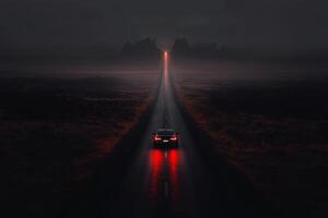 Mysterious road illuminated by a car under a dark, moody sky at dusk. photo