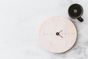 Circle clock and a coffee cup on a minimalist desk in a cozy workspace. photo