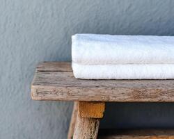 Soft towels resting on a rustic wooden shelf photo