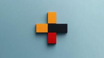 Creative arrangement of colorful wooden blocks forming a bold plus sign on a soft blue backdrop in a minimalist setting photo
