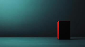 Bright red and black cube stands out against a moody teal background with subtle shadows and light play in a creative space photo