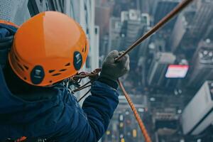 Daring descent from a skyscraper in the heart of the city at dawn with an expert climber navigating the heights photo