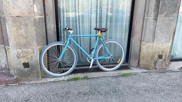 Bicycles resting by building with elegant window attire photo