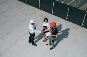 Doing handshake. Top view ,of men and woman that are on construction site, working together on the project photo