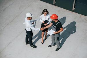 Doing,handshake. Top view of men and woman that are on construction site, working together on the project photo