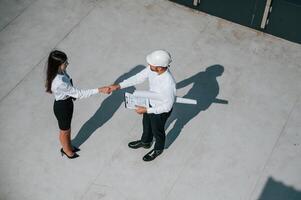Successful deal, doing handshake. Man with woman ,are working on the construction project together outside photo