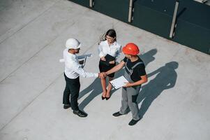 Doing handshake. Top, view of men and woman that are on construction site, working together on the project photo