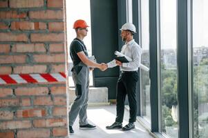 Manager with foreman, are working on the construction site together photo