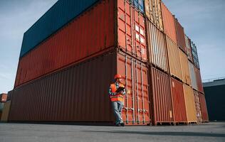 Digital tablet in hands. Male worker, is on the location with containers photo