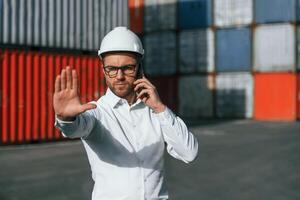 Restricted area. No trespassing. Male worker is on the location with containers photo