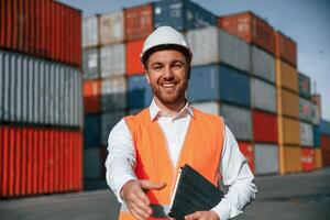 Giving hand to make ,handshake, successful deal. Male worker is on the location with containers photo