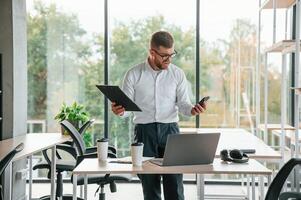 Angry, feeling ,tired and bad.. Man in formal clothes is working in the modern office photo