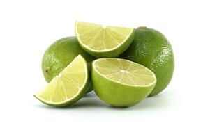 Fresh limes and lime slices resting on white background photo