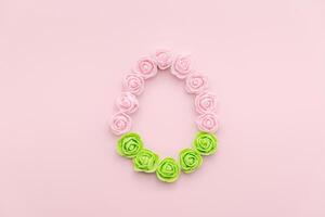 Rosebuds egg shape on pink background with green bottom photo