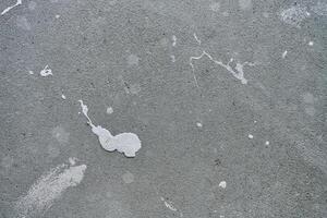Close-up of concrete wall with white paint splashes and rough texture. Background for construction and renovation concep photo