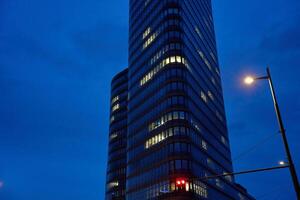 Modern high-rise office building with illuminated windows at night photo