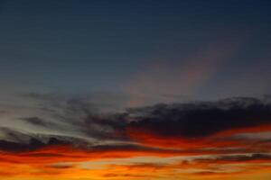 Dramatic orange clouds and sunrays at sunset photo