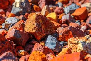 A close-up shot of red stones scattered on the ground, with a natural background that emphasizes the earthy texture and vibrant color of the stones in their natural environment. photo