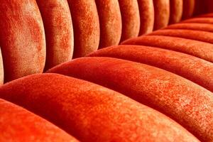 A close-up view of the rich and luxurious texture of a red velvet sofa, highlighting its softness and elegant appearance photo