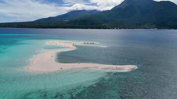 erial drone view of white island sandbar with Camiguin Island in the background. Clear tropical waters and volcanic mountain video