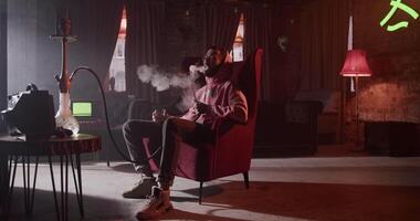 Relaxing man with hookah and drink in bar video