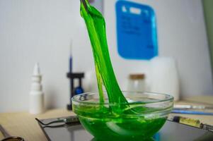 Close up photo is a stretchy green gel-like substance lying in a laboratory dish. A substance for clinical trials of new cosmetics and perfumes for extracting fragrance from a biological base. Memory