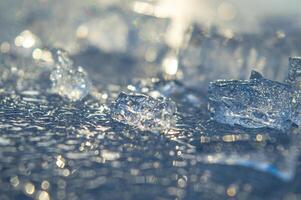 Beautiful transparent different pieces of ice on the ice surface. Pieces of ice filled with bubbles, a solid background. dishes, frozen water is clean. High quality photo