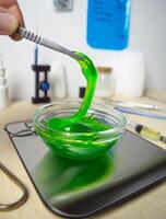 The slime green substance in the laboratory dish is pulled with tweezers. Research and scientific discoveries on the table in the laboratory. High quality photo