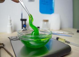 Close up photo is a stretchy green gel-like substance lying in a laboratory dish. A substance for clinical trials of new cosmetics and perfumes for extracting fragrance from a biological base. Memory