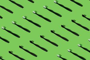 Organic plant based toothbrush pattern composition on green background. Minimal dental concept. Creative eco friendly, biodegradable and natural wooden toothbrush pattern backdrop idea. photo