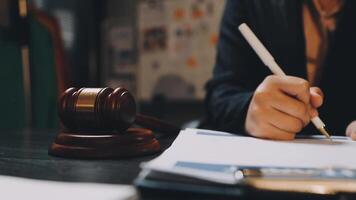 A judge's gavel is sitting on a desk with a pen and paper video