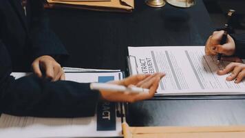 Two people sitting at a table with papers and pens video