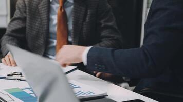 Two business people sitting at a table with laptops video