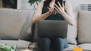 A woman sitting on a couch with a laptop and a glass of juice video
