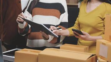 A woman and man are standing in front of boxes and laptops video