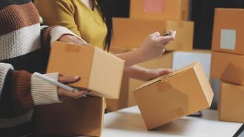 Two people are holding boxes and a laptop video