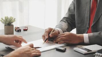 Two people in suits are signing papers at a desk video