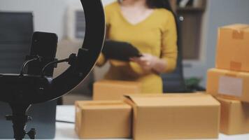 A woman is holding a camera and a microphone in front of boxes video